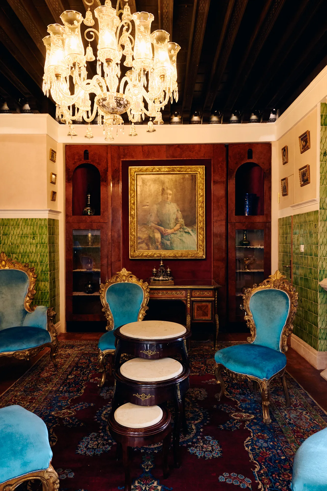 A salon furnished with turquoise velvet armchairs.