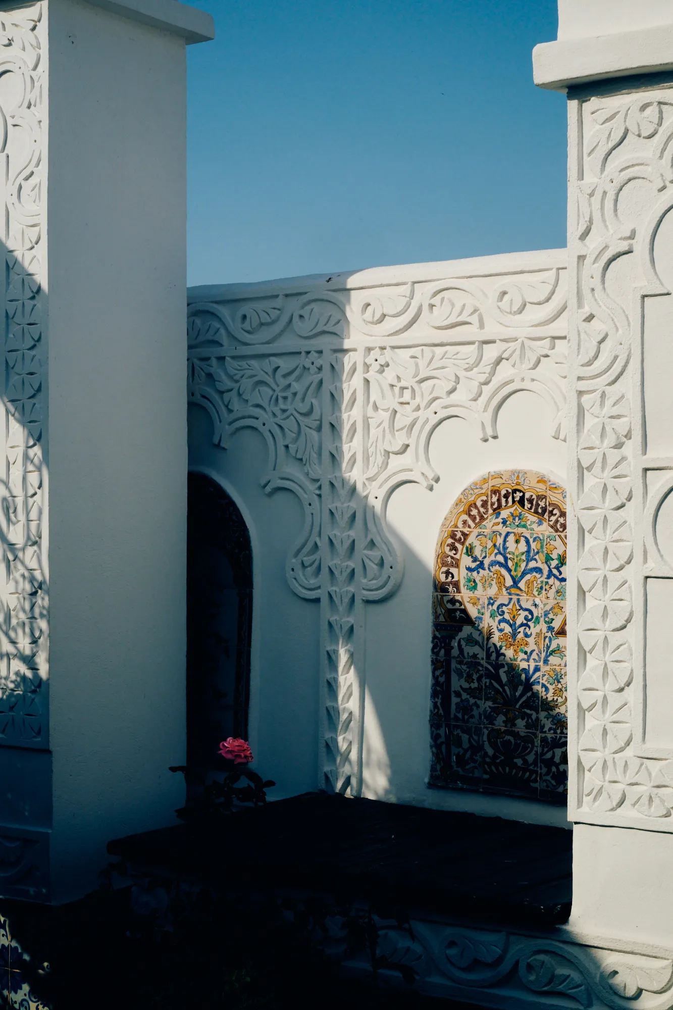 A courtyard of white carved plaster under an open sky.