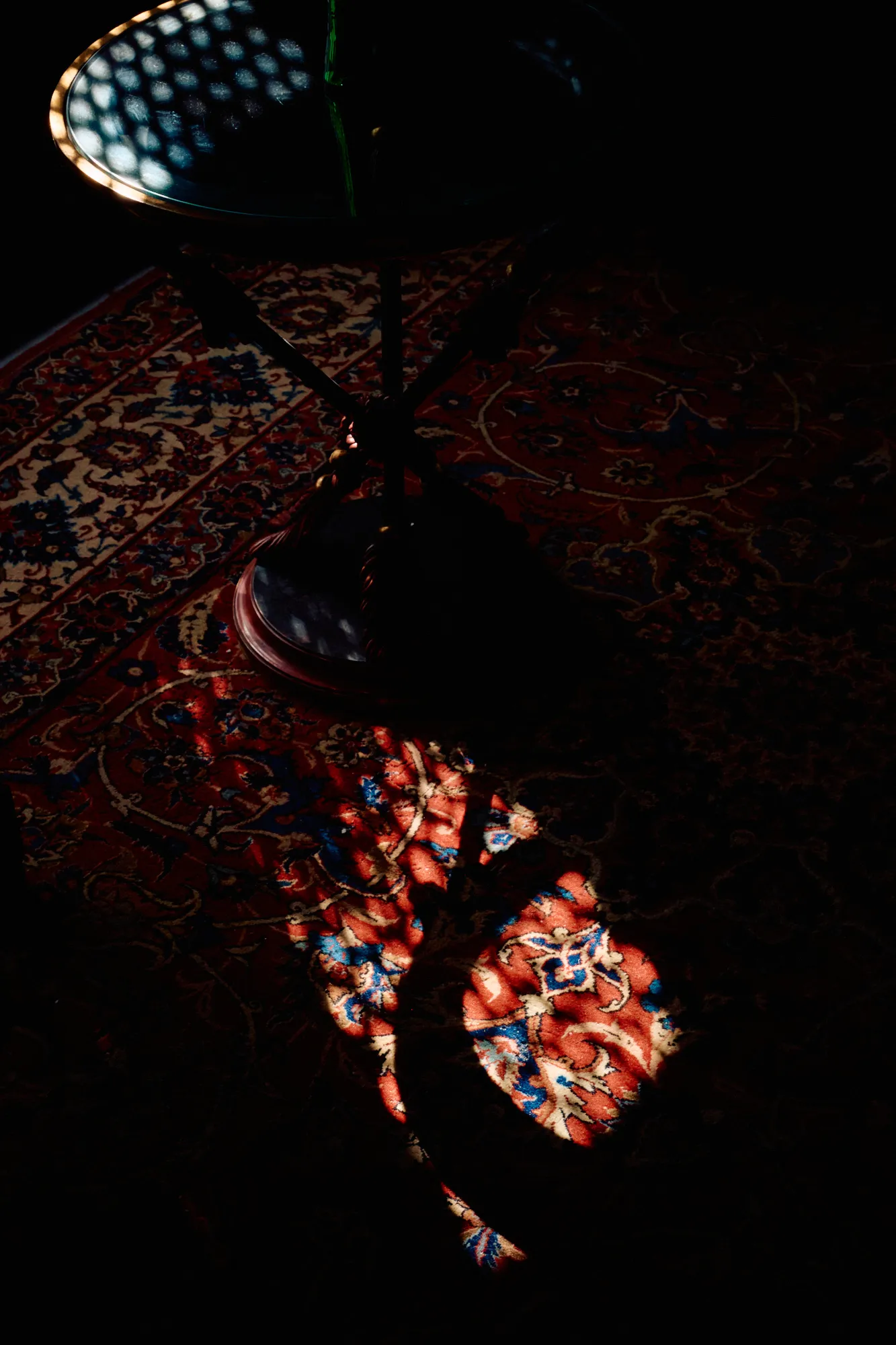 Coloured light cast across a woven carpet.