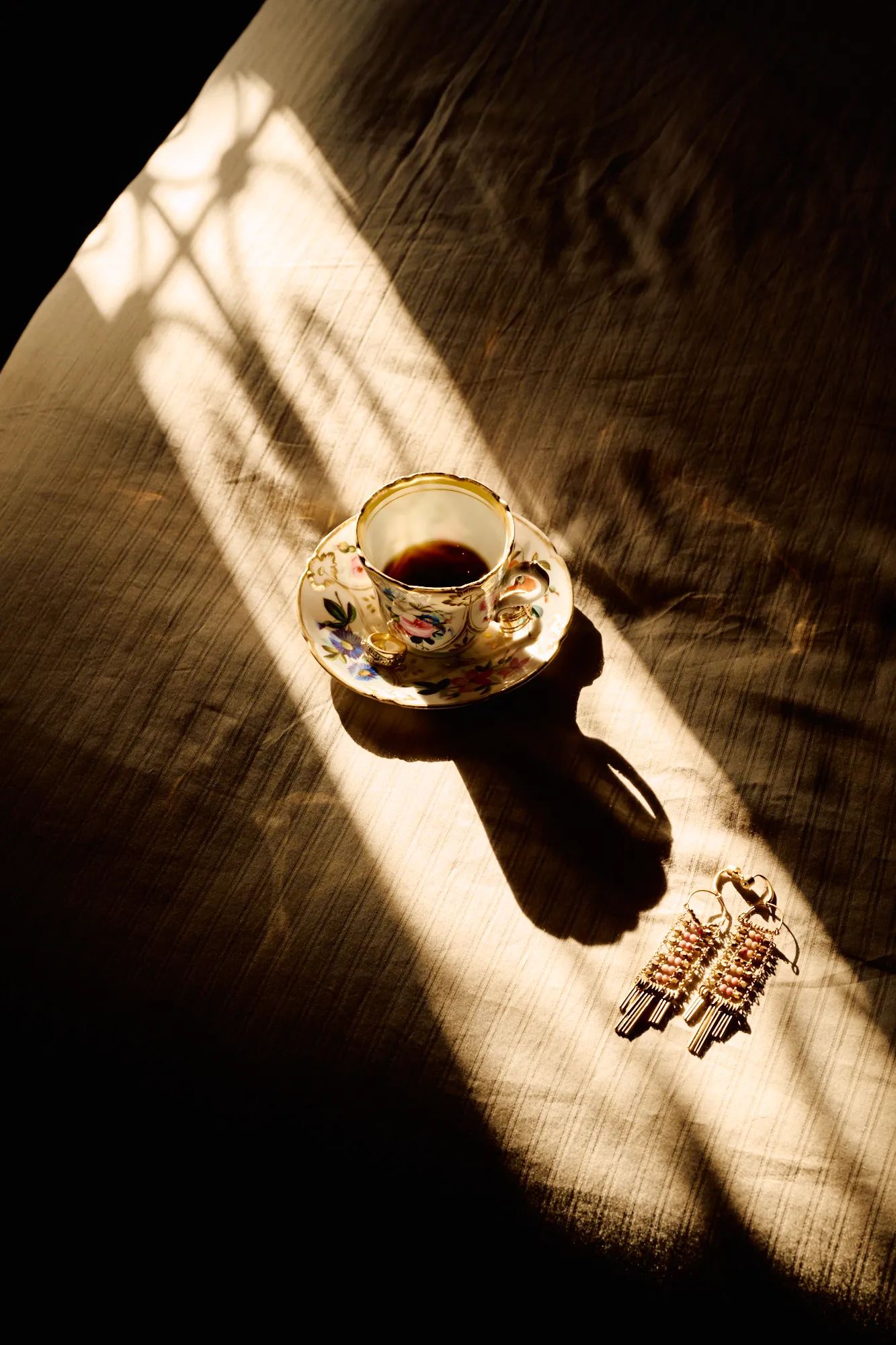 A gilded tea cup in a shaft of sunlight.