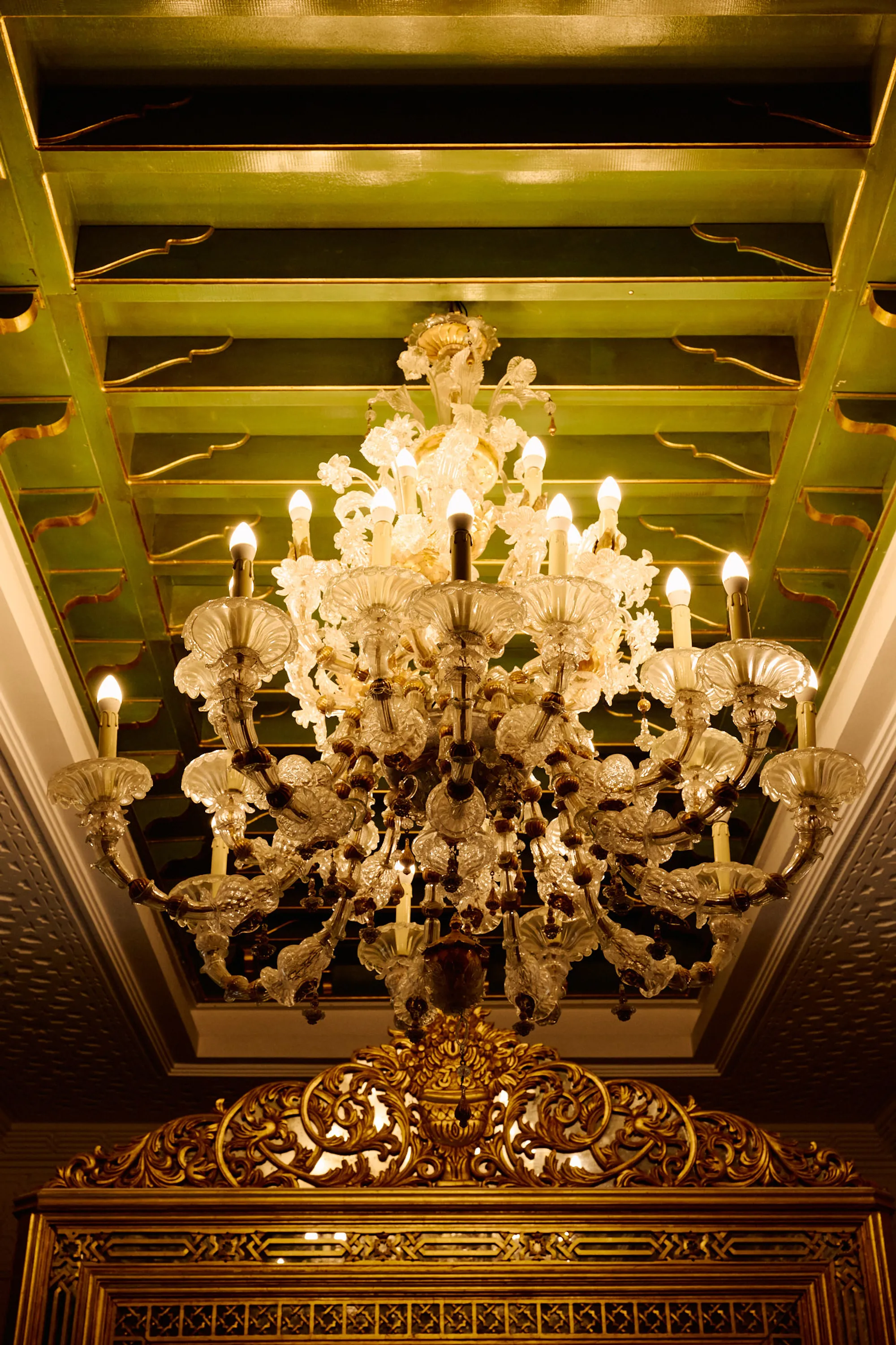 A gilded ceiling and a crystal chandelier.