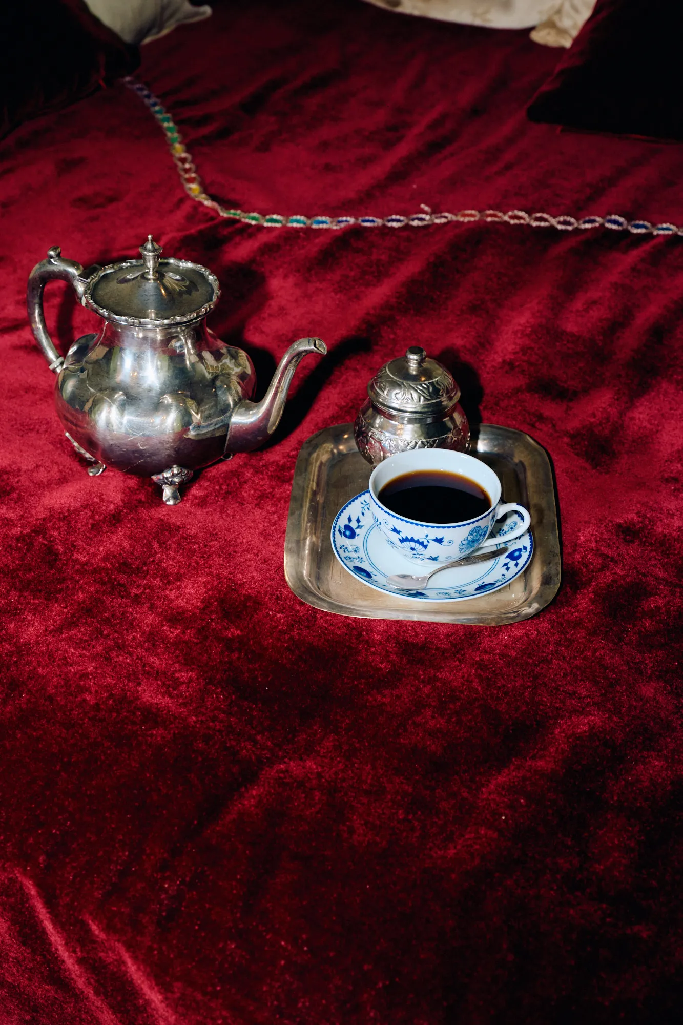 A silver tea service set on red velvet.