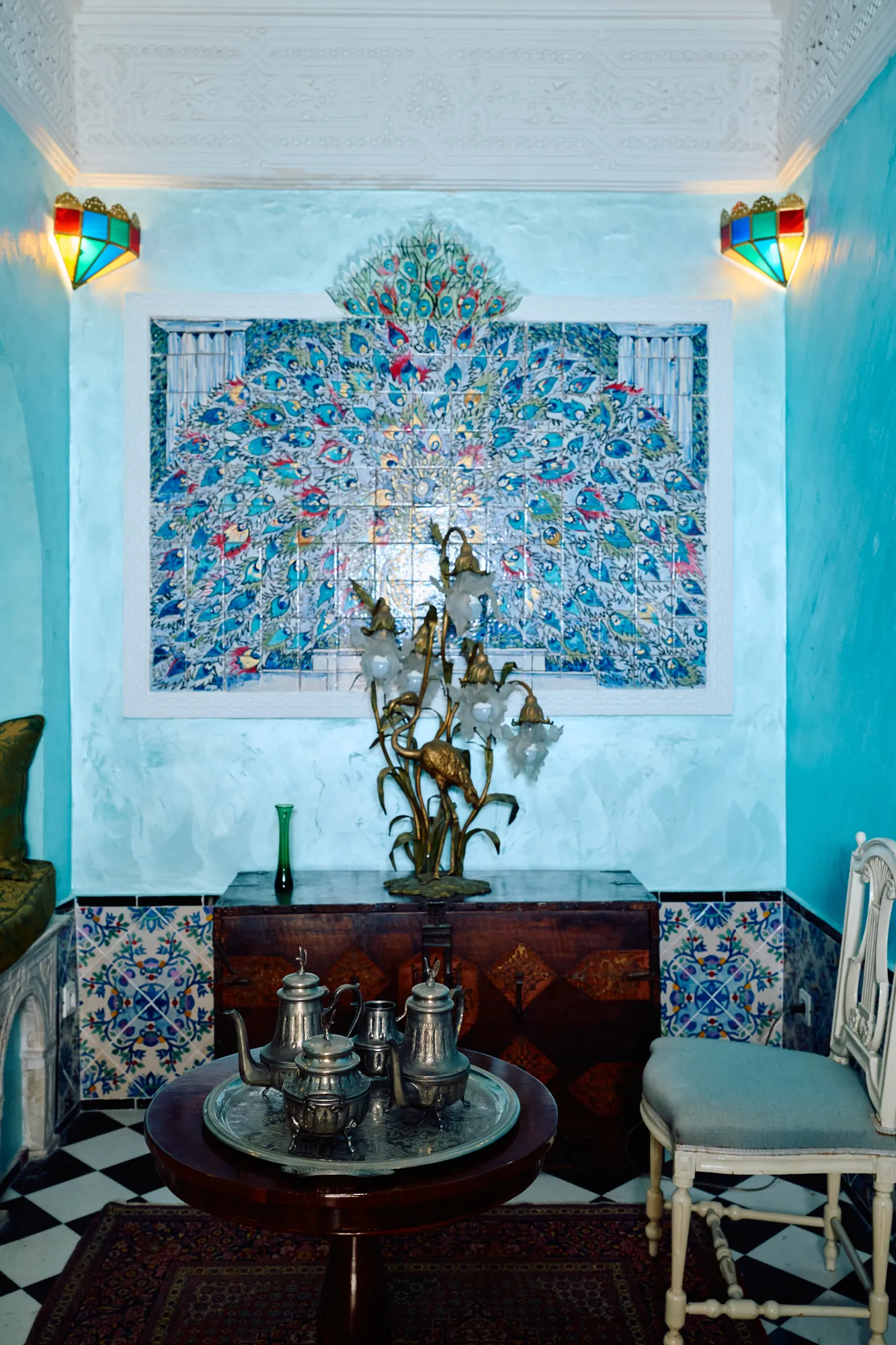 A console beneath a tiled panel, against turquoise walls.