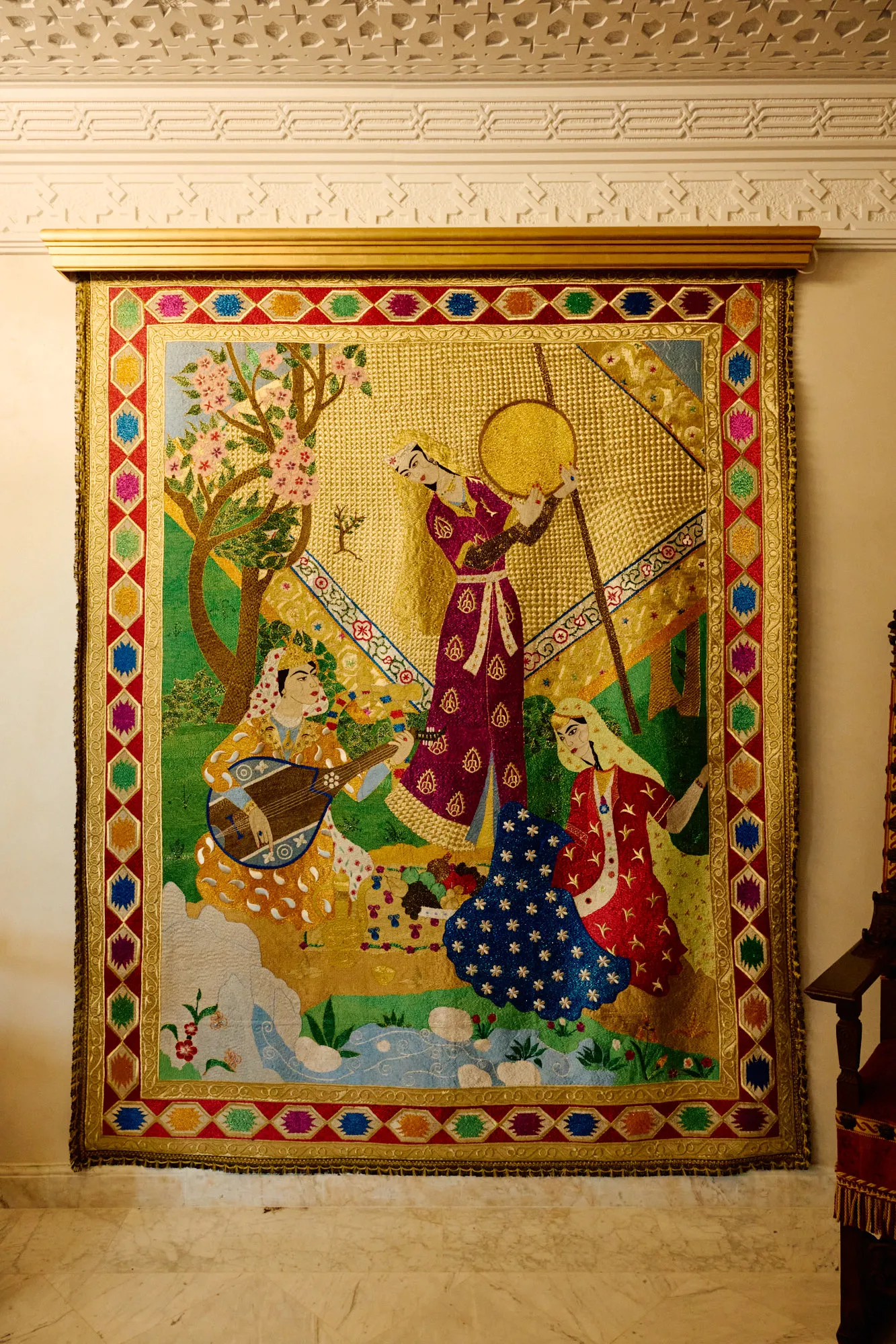 A large framed artwork of female musicians on a white plaster wall.
