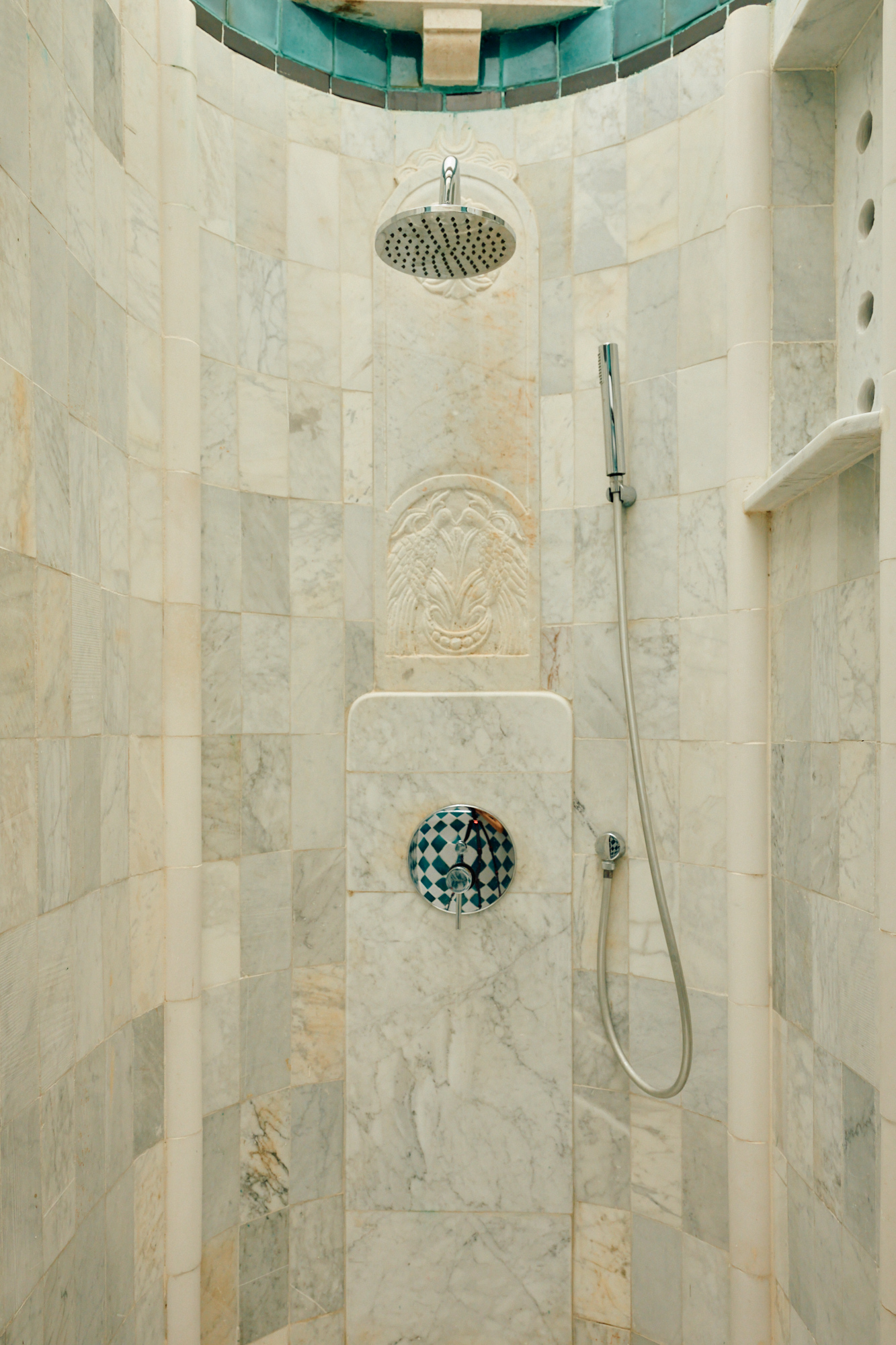 Une douche de marbre logée dans une niche sculptée.