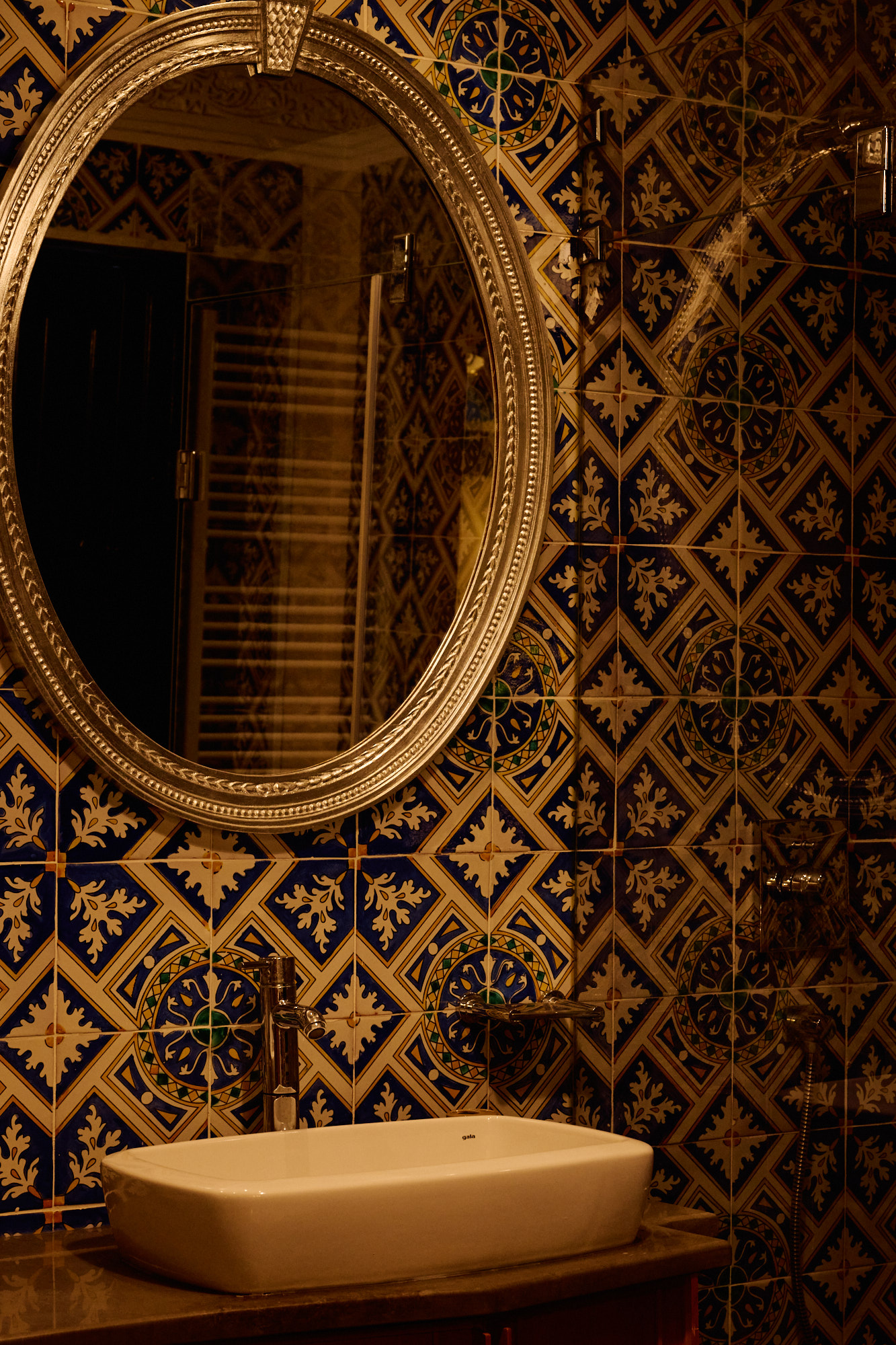 Une salle de bain en faïence bleue, avec une vasque de pierre.